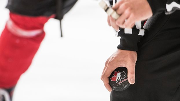 A Hockey Canada official holds a puck before a faceoff