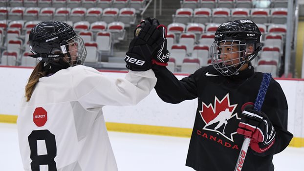 Two players high-five on the ice.