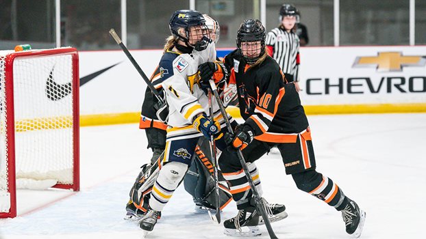 A Prince Albert Bears player battles for position against an opponent in front of her net.