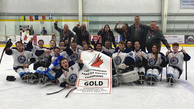 Équipe Québec pose avec sa bannière après avoir gagné le Championnat canadien de parahockey sur glace en mai 2022.