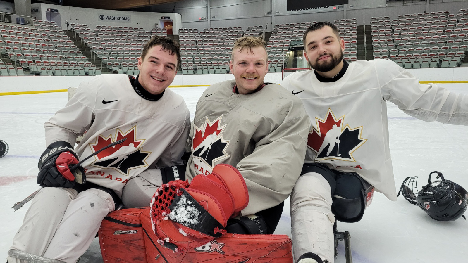 Matteo Pellizzari (left), Mitchell Garrett and Brendon Hurst smile in their sleds on the ice during selection camp.