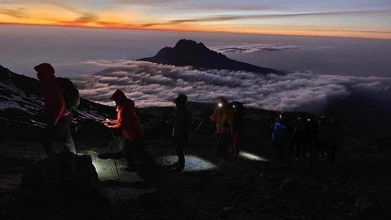 Un groupe de marcheurs monte le mont Kilimandjaro dans un décor splendide.