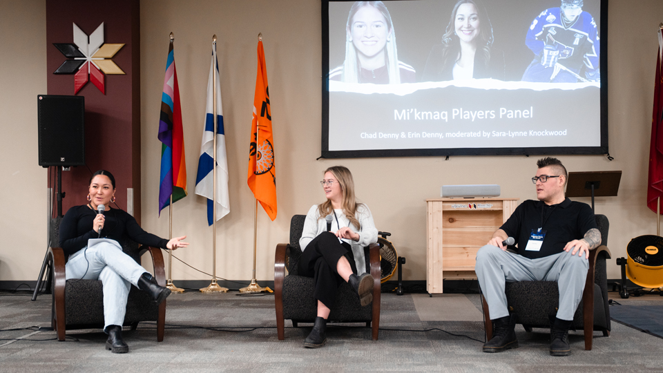 Sara-Lynne Knockwood (left), Erin Denny and Chad Denny during the Mi'kmaw players' panel. They are sitting in chairs with a projection screen behind them showing the name of the panel.