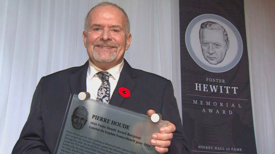 Pierre Houde tient fièrement sa plaque du prix
Foster-Hewitt du Temple de la renommée du hockey