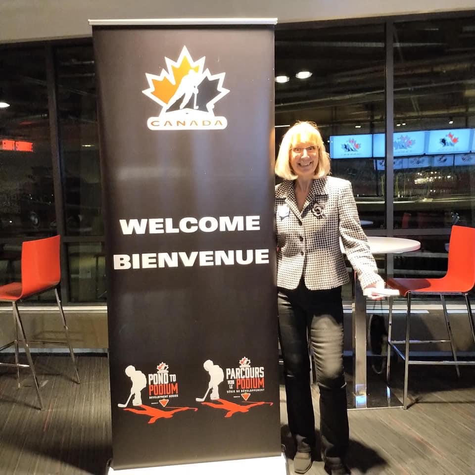 Susan Sloan poses beside a Hockey Canada welcome sign